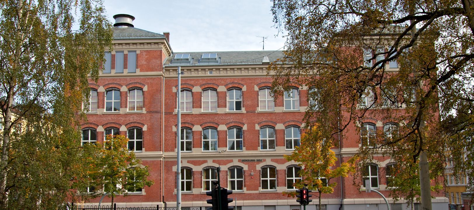 en stor murbygning med trær foran