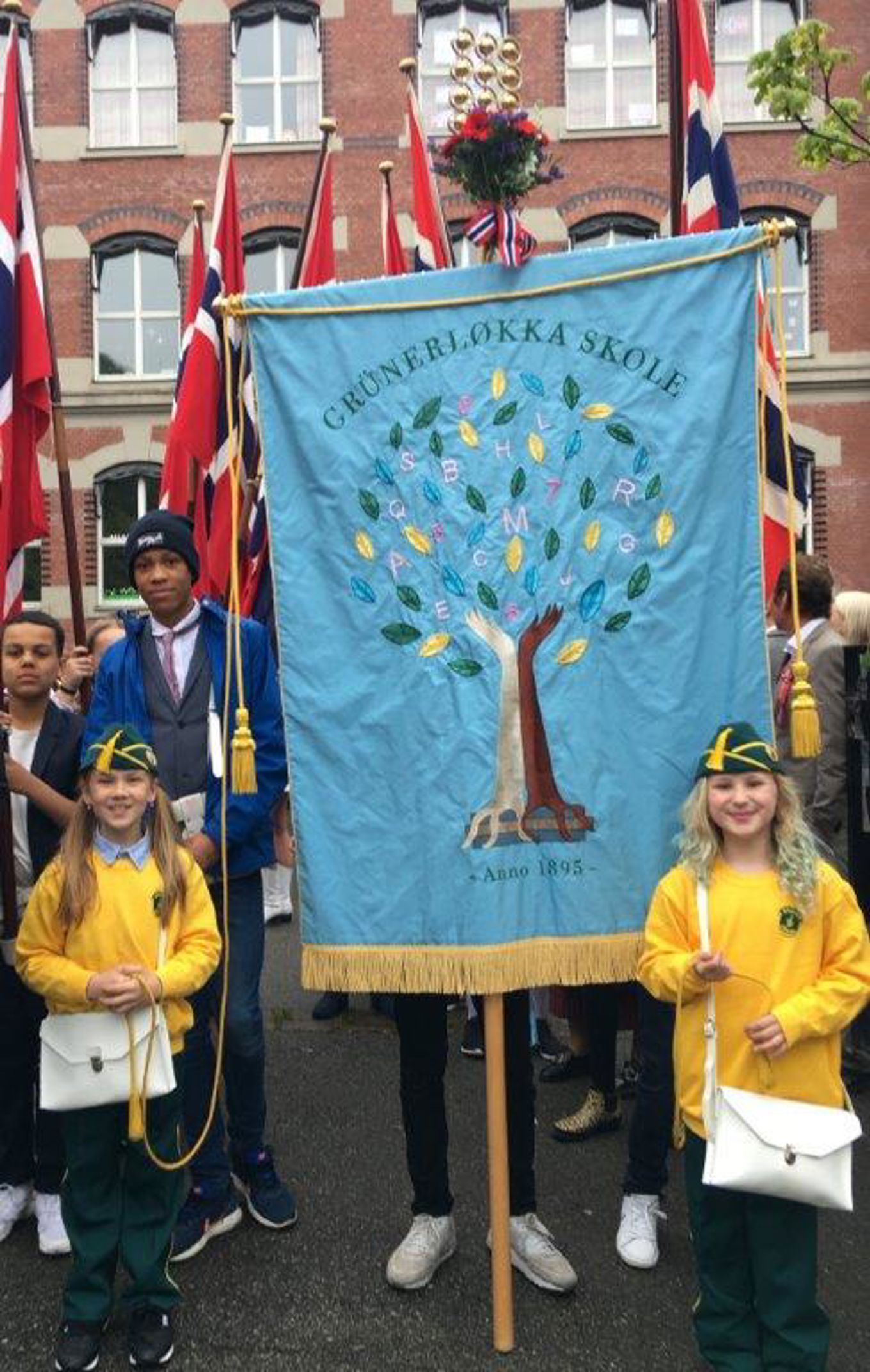 Bilde av skolens lyseblå fane. På fanen er det avbildet et tre.